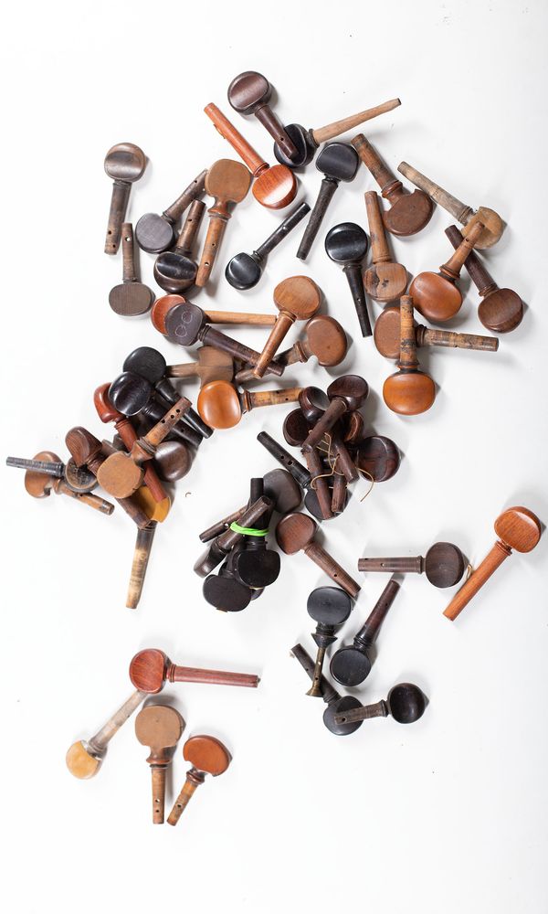 A bundle of sixty-one cello pegs, varying sizes