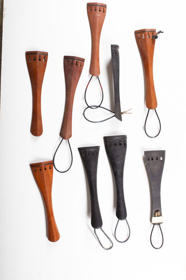 A bundle of twenty-two cello tailpieces, varying sizes