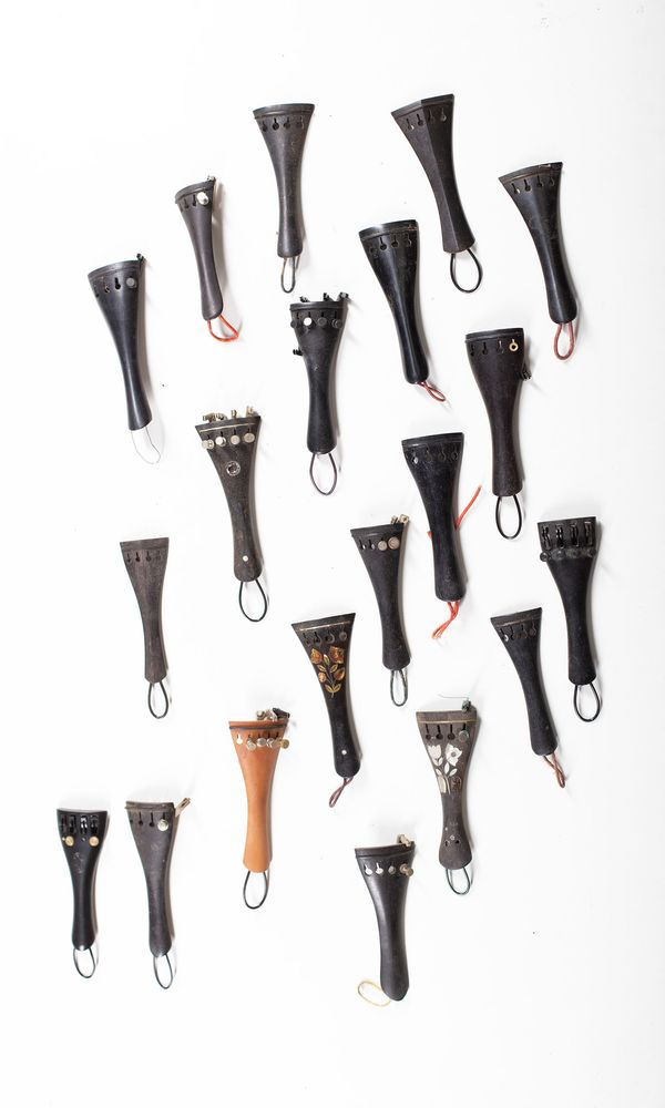 A bundle of fifty-four violin tailpieces, varying sizes