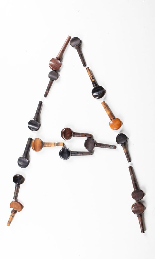 A bundle of sixteen cello pegs, varying sizes