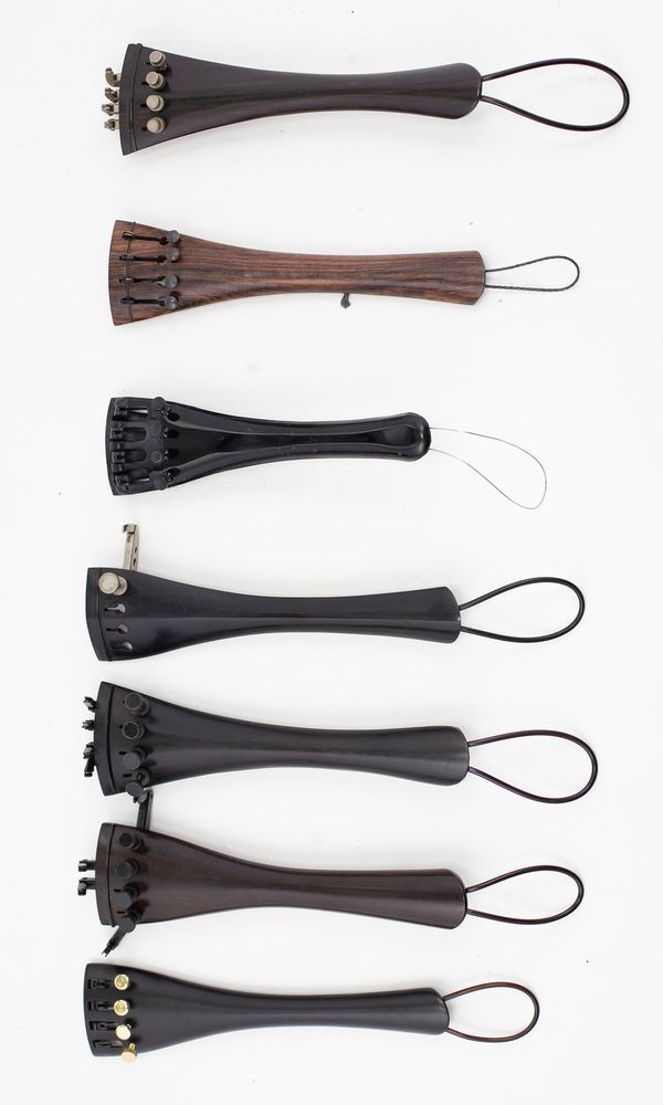 One  cello tailpiece, branded Wittner and Seven cello tailpieces unbranded