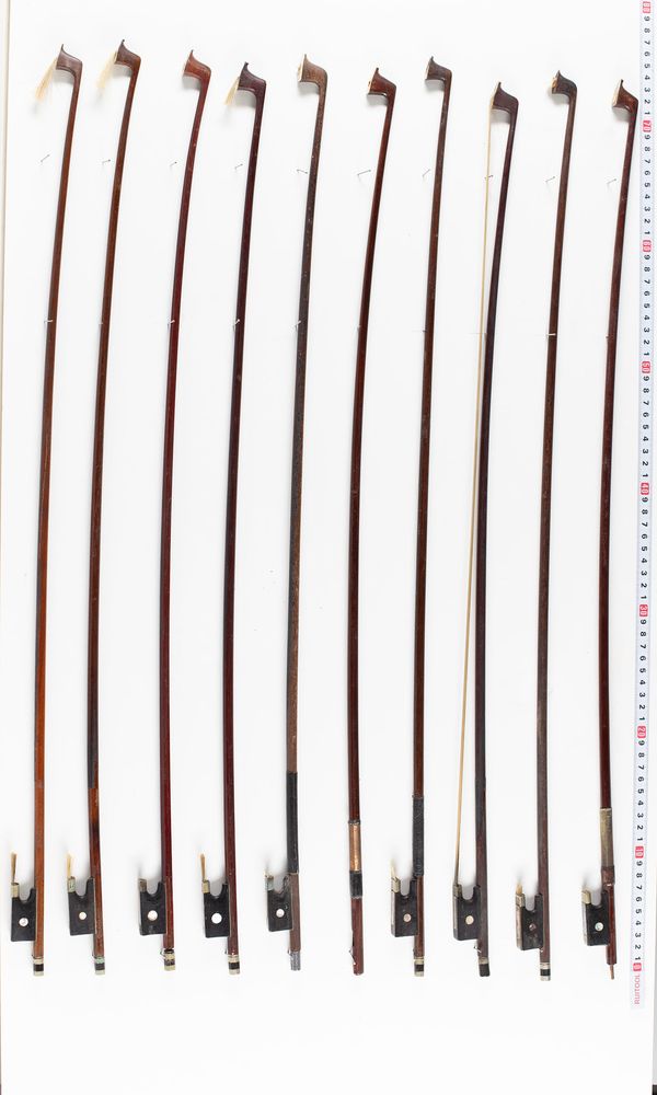 A bundle of ten violin bows and one bow stick, varying sizes