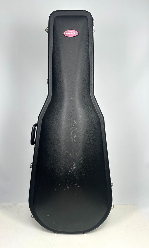 A cello case, branded SKB