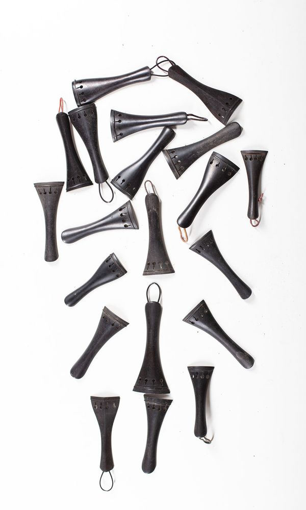 A bundle of twenty violin tailpieces, varying sizes