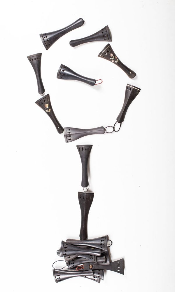 A bundle of twenty violin tailpieces, varying sizes