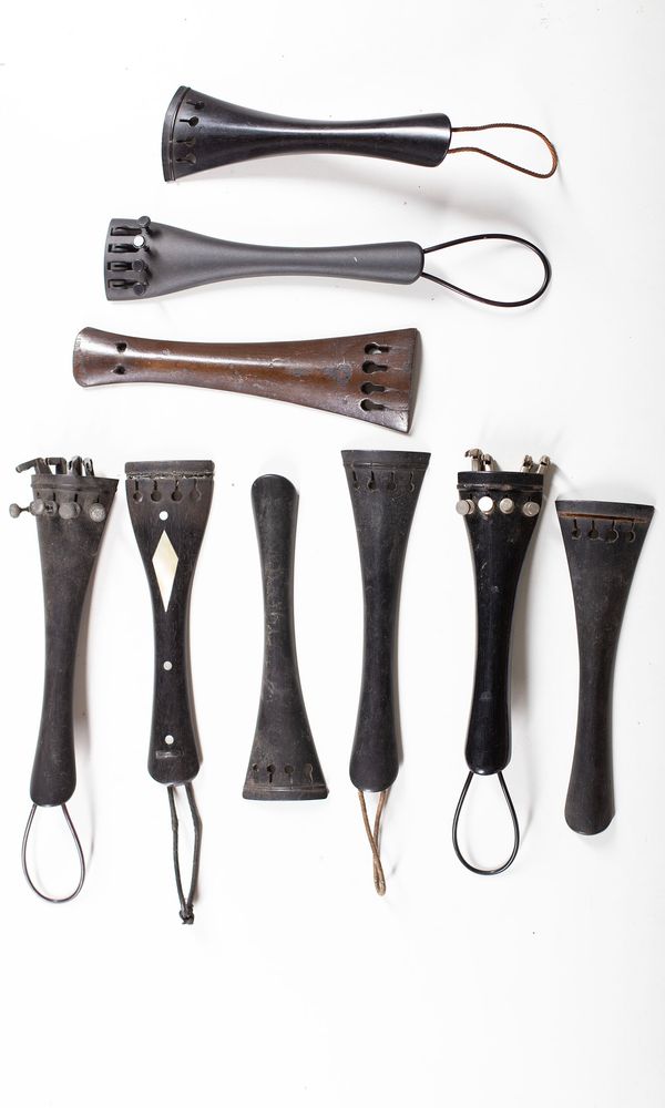A bundle of fifteen cello tailpieces, varying sizes
