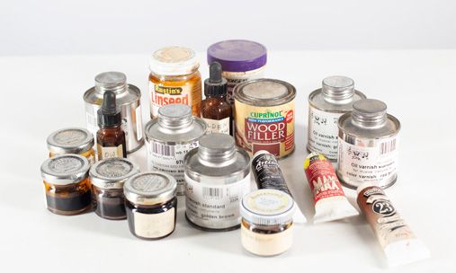 A box of various bottles of varnish and oil paints