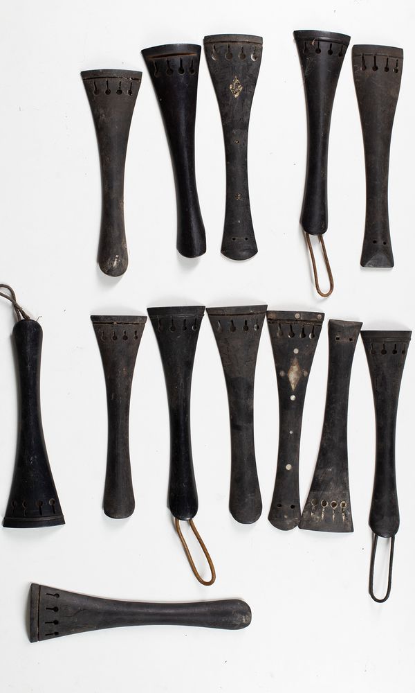 Fifteen cello tailpieces and two double bass tailpieces