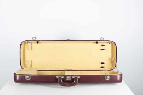 A violin case, branded Gewa