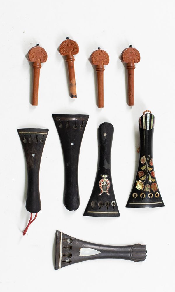Five decorative tailpieces and a set of decorative pegs