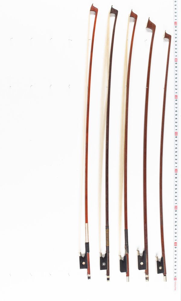 Approximately nine violin bows and one cello bow, varying lengths