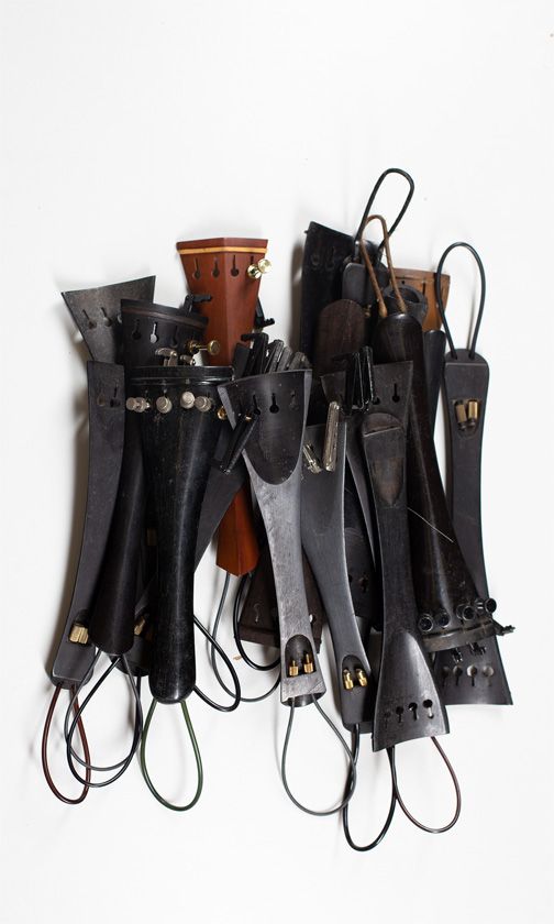 Thirty-two cello tailpieces of various sizes