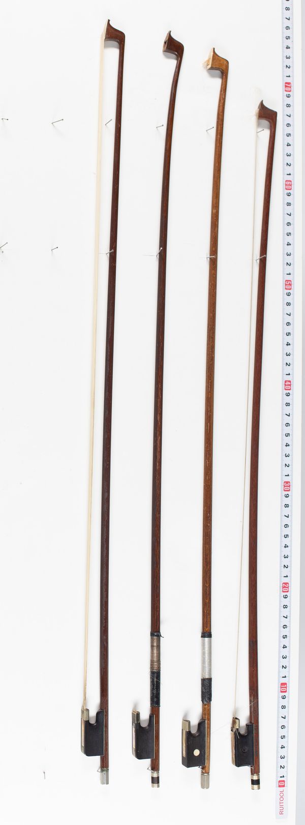 Four violin bows, varying lengths