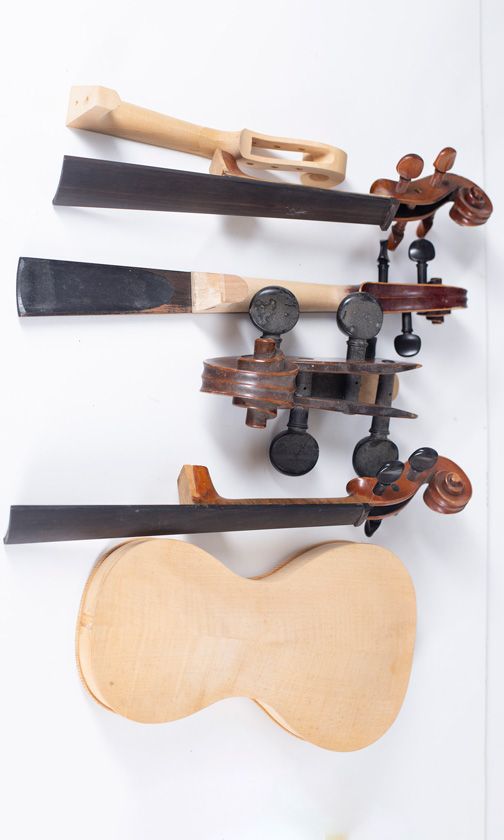 Four violin scrolls, one cello scroll and one violin body