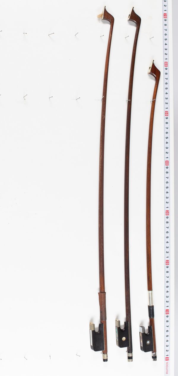Three cello bows, varying lengths