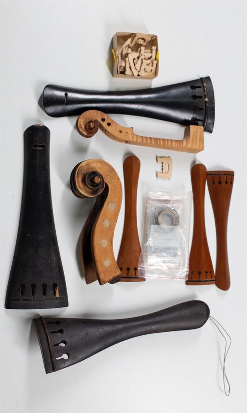 Three bass tailpieces, three cello tailpieces, one cello scroll, one violin scroll, seventeen bridges and a quantity of purfling