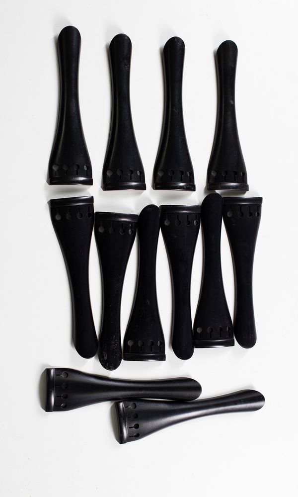 Twelve ebony cello tailpieces