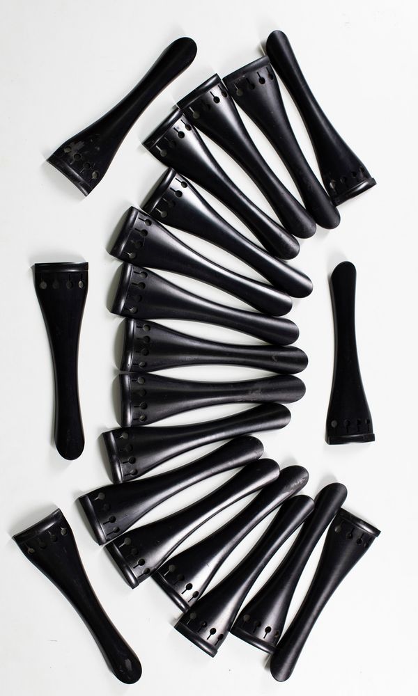 Twenty ebony cello tailpieces
