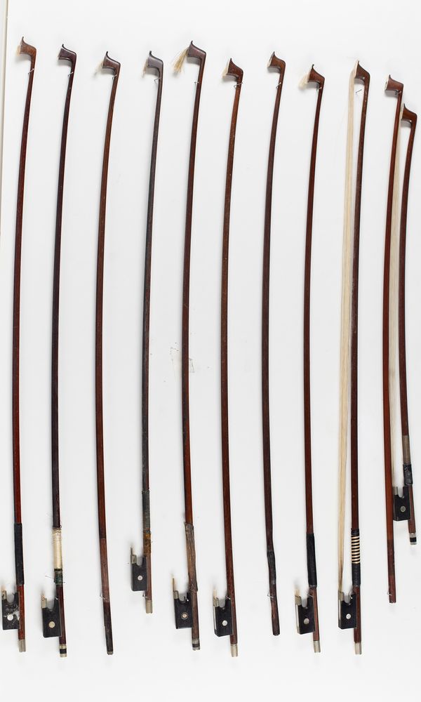 A bundle of sixteen violin bows and one bass bow, varying lengths