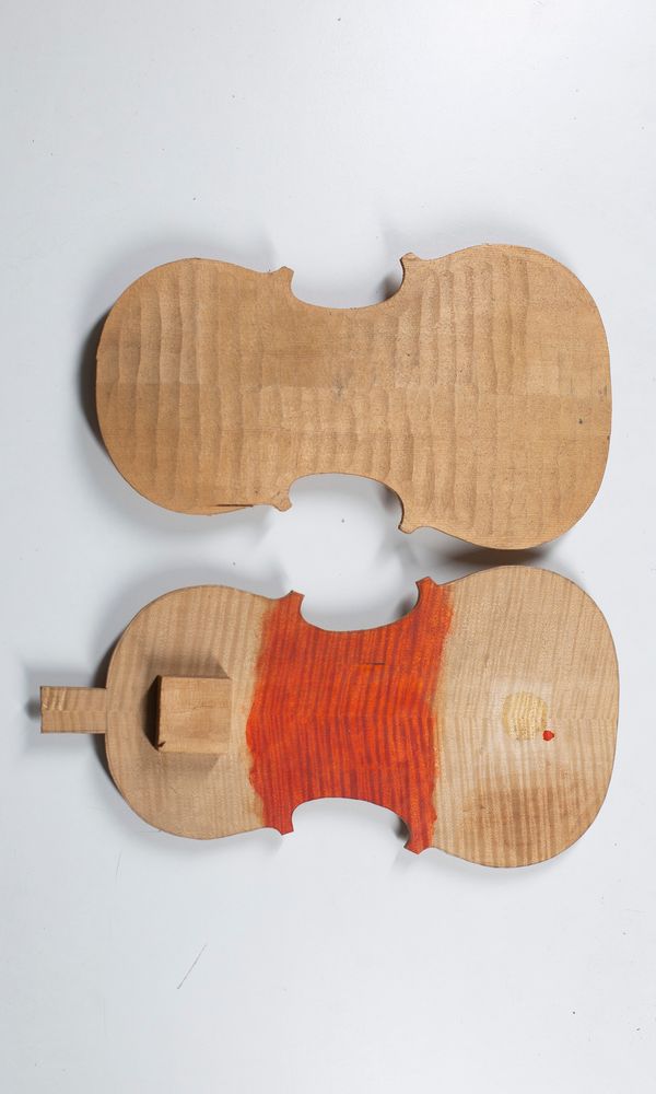 A partially complete violin front and back