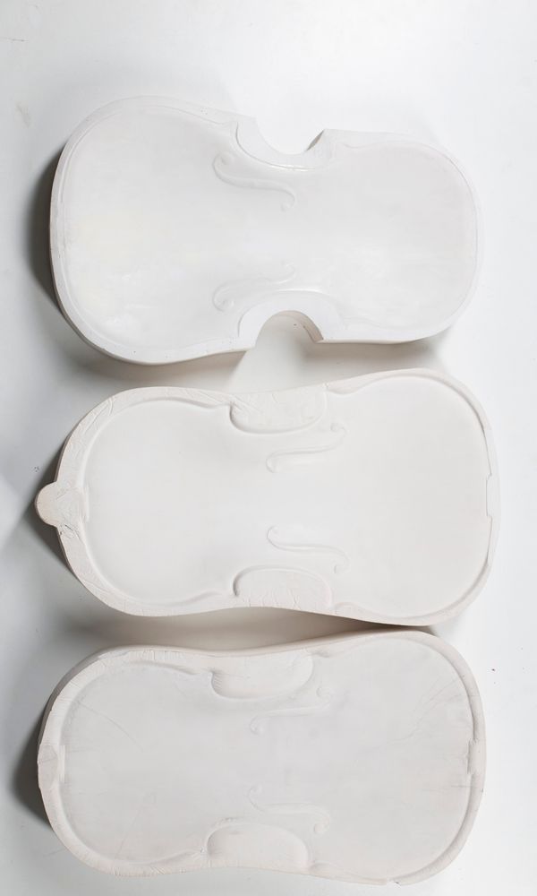 Three plaster moulds of violin fronts, including one of T. Balestrieri