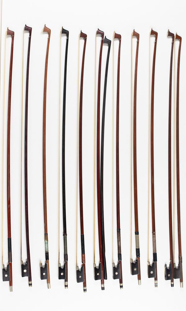 Eleven violin bows and one bow stick