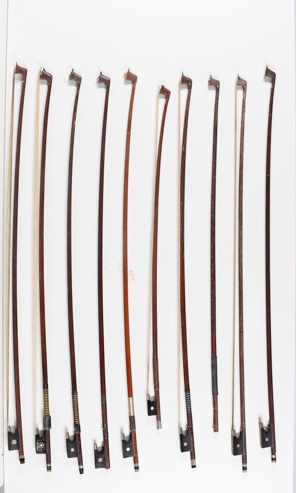 Nine violin bows and a bow stick, varying lengths