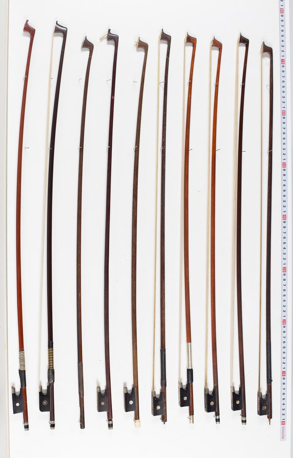 Nine violin bows and one violin stick, varying lengths