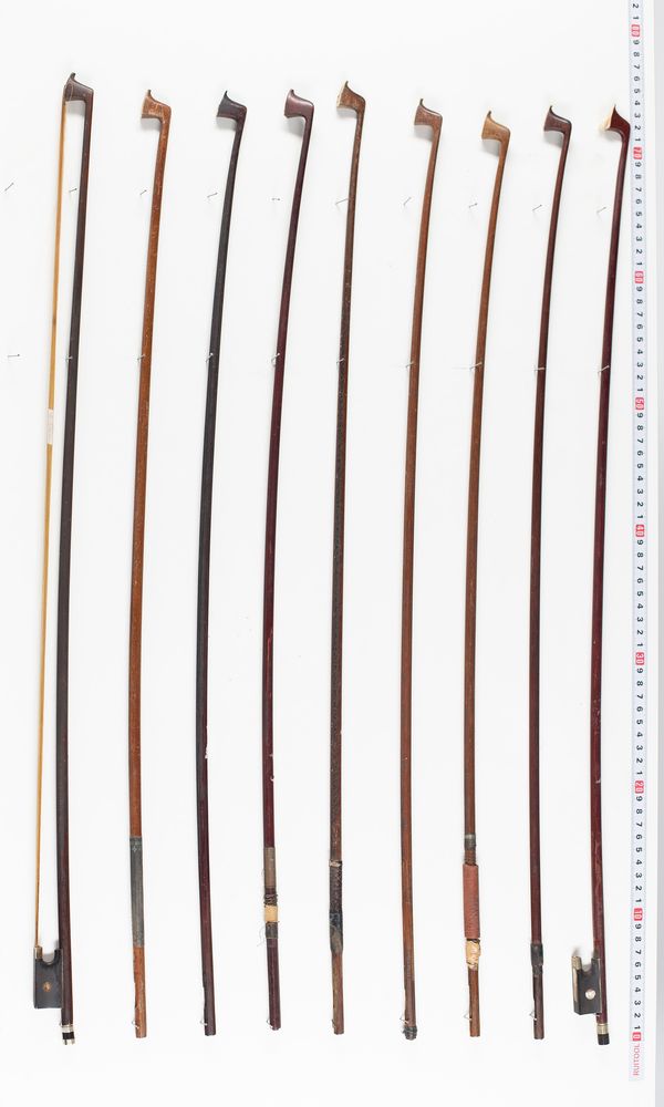 Two violin bows and seven bow sticks, varying lengths