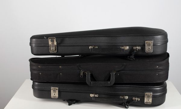 Three black half-size violin cases
