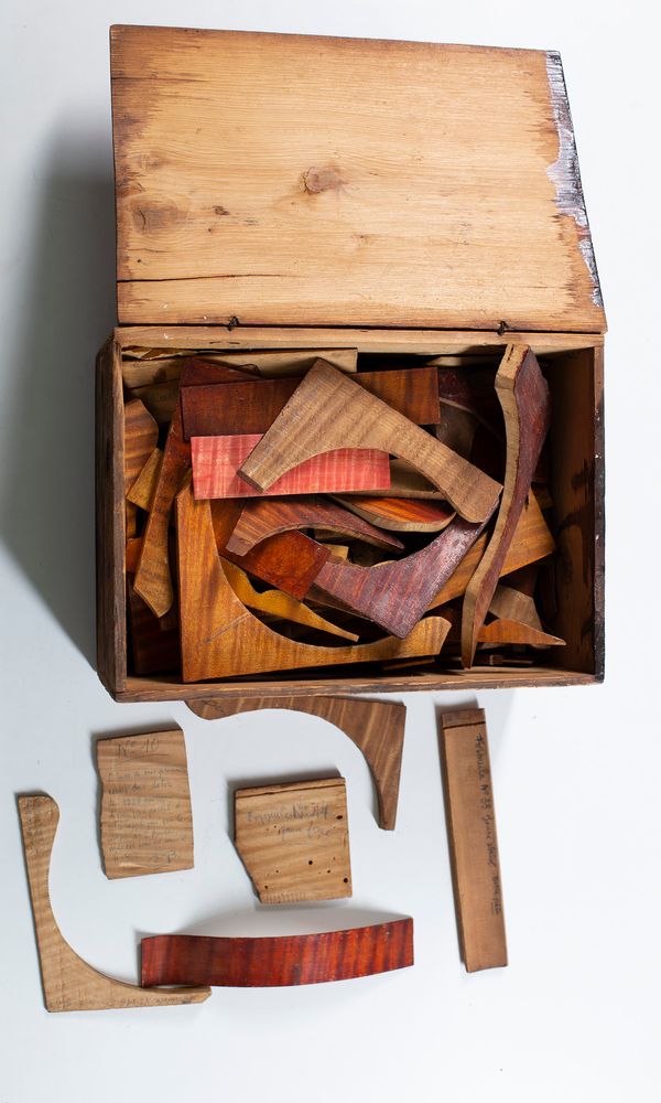 A box of various pieces of wood on which different samples of varnish tested and notes made