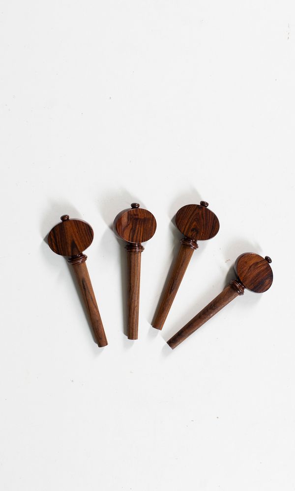 A set of four rosewood cello pegs