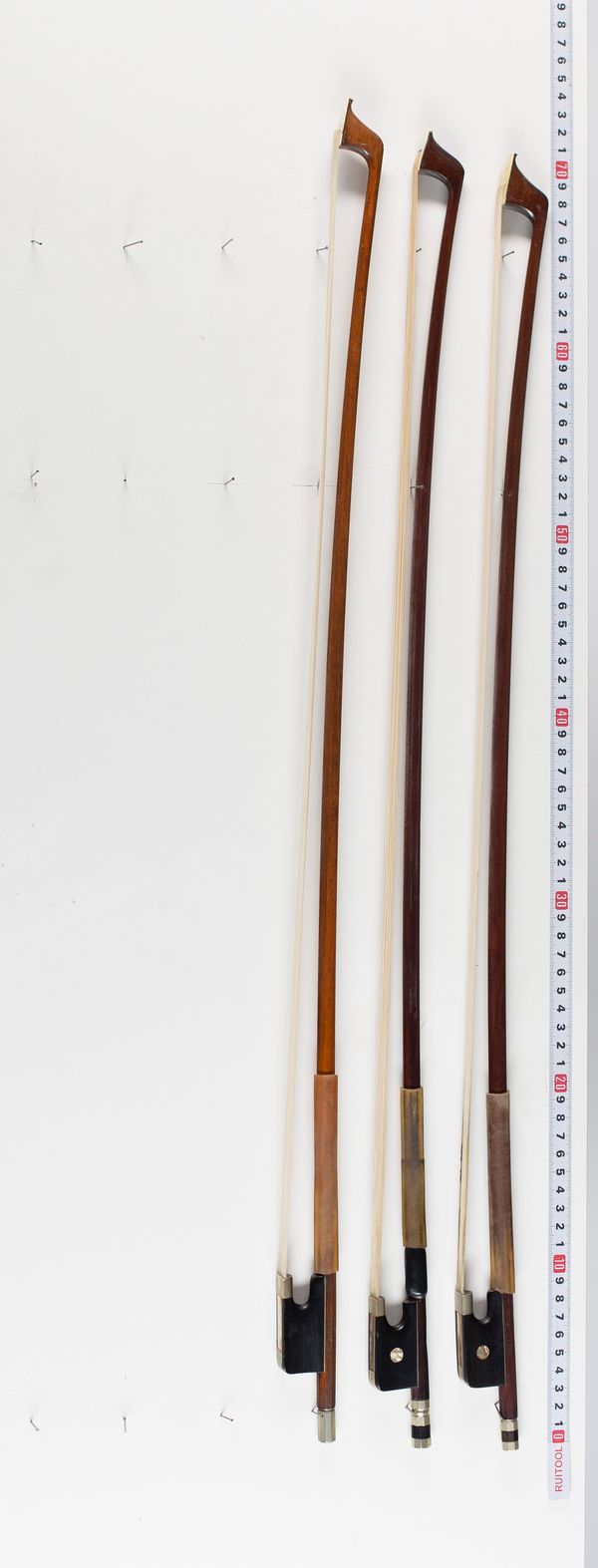 Three cello bows, varying sizes