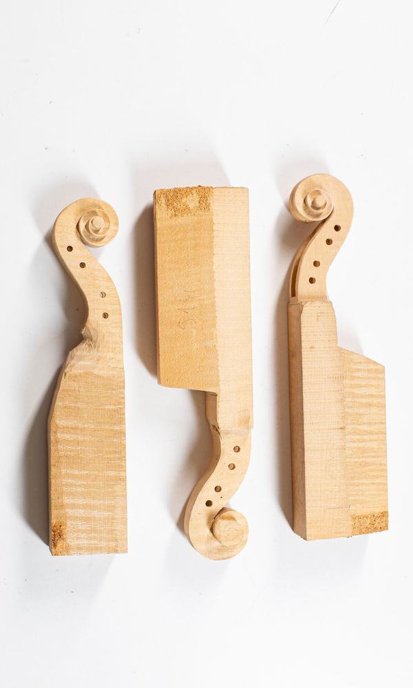 Three partially made violin scrolls