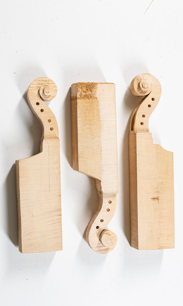 Three partially made violin scrolls