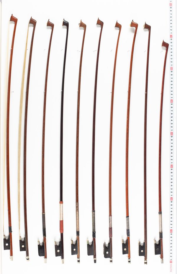 Approximately eleven violin bows, varying lengths