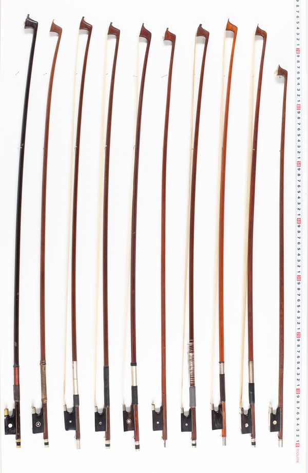 Approximately twelve violin bows, varying lengths