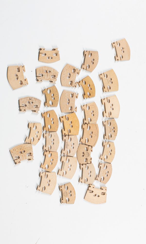 Thirty violin bridges, varying sizes