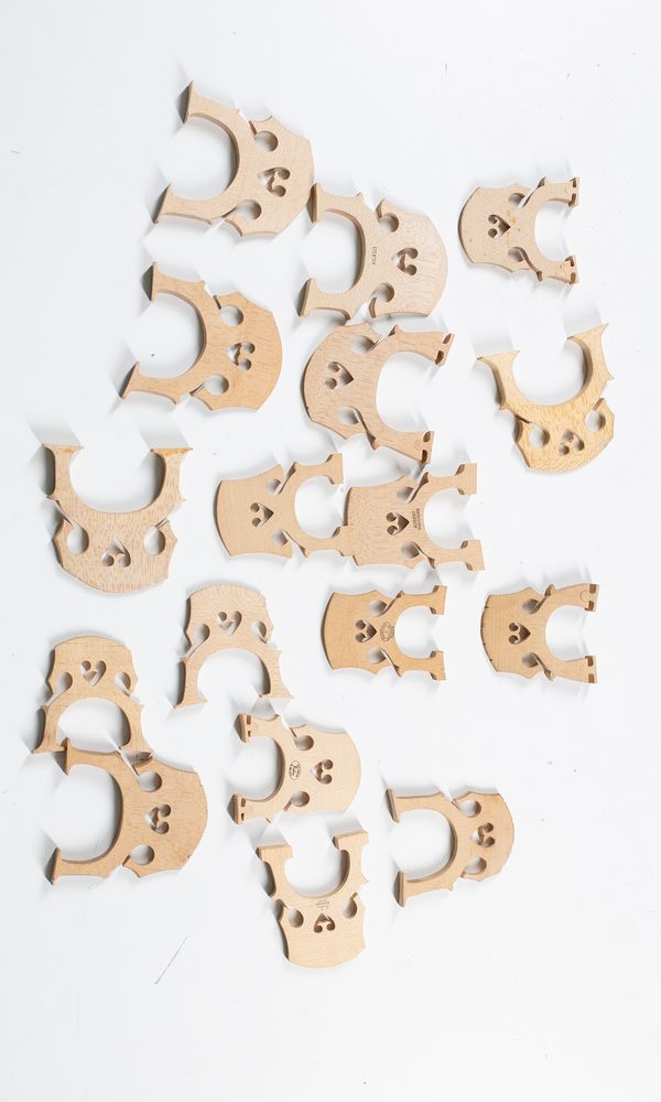 Seventeen cello bridges, varying sizes