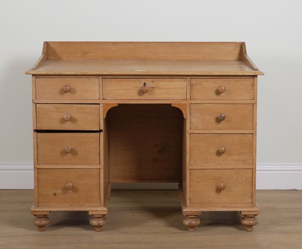 A VICTORIAN PINE KNEEHOLE NINE DRAWER WRITING DESK