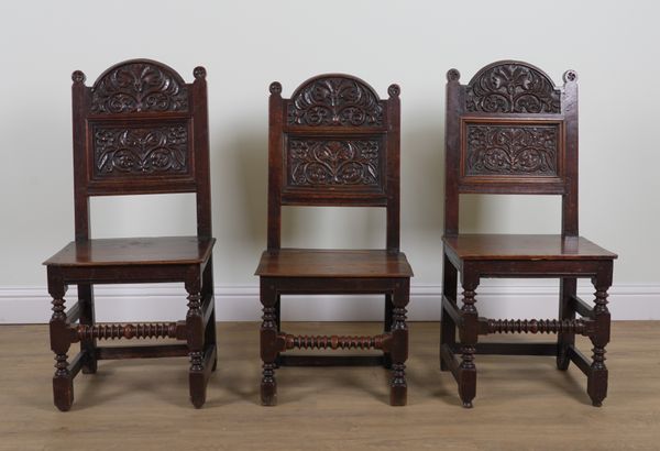 A PAIR OF CHARLES II CARVED OAK PANEL BACK CHAIRS (3)