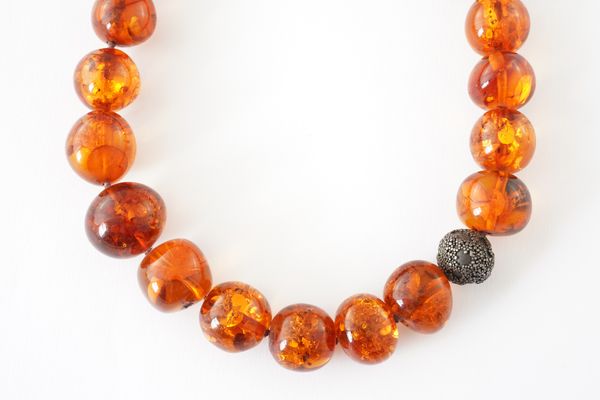 A SINGLE ROW NECKLACE OF TRANSLUSCENT GRADUATED AMBER BEADS