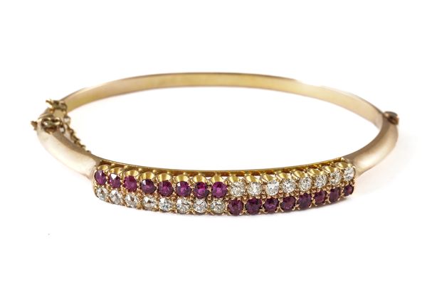 A GOLD, RUBY AND DIAMOND OVAL HINGED BANGLE