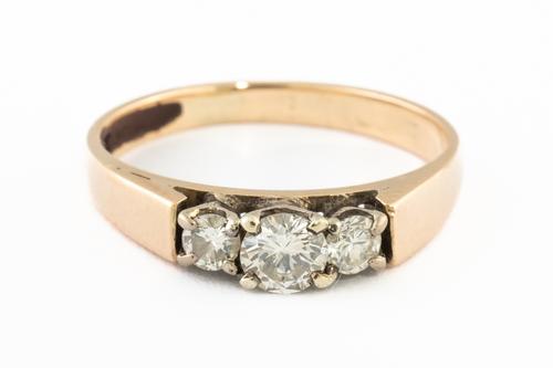 A GOLD AND DIAMOND THREE STONE RING