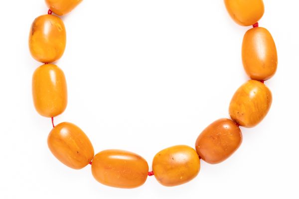 A SINGLE ROW NECKLACE OF GRADUATED VARICOLOURED BUTTERSCOTCH AMBER BEADS