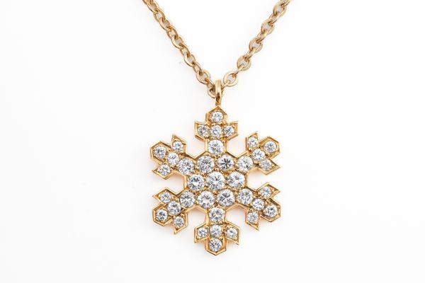 A GOLD AND DIAMOND PENDANT NECKLACE IN A HEXAGONAL SNOWFLAKE DESIGN