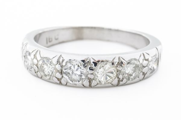 A WHITE GOLD AND DIAMOND SEVEN STONE HALF ETERNITY RING