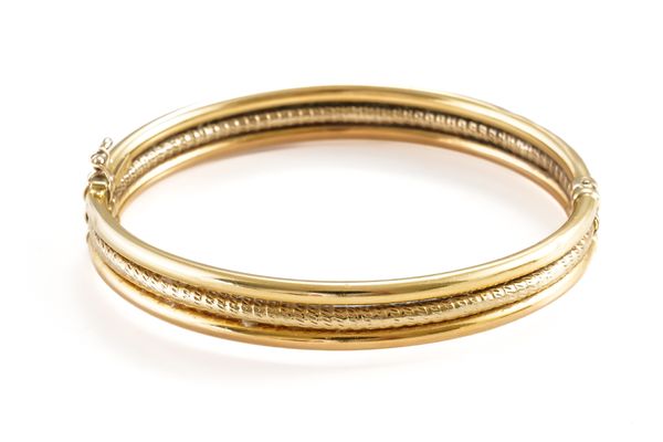 A TWO COLOUR GOLD OVAL HINGED BANGLE