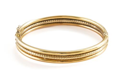 A TWO COLOUR GOLD OVAL HINGED BANGLE