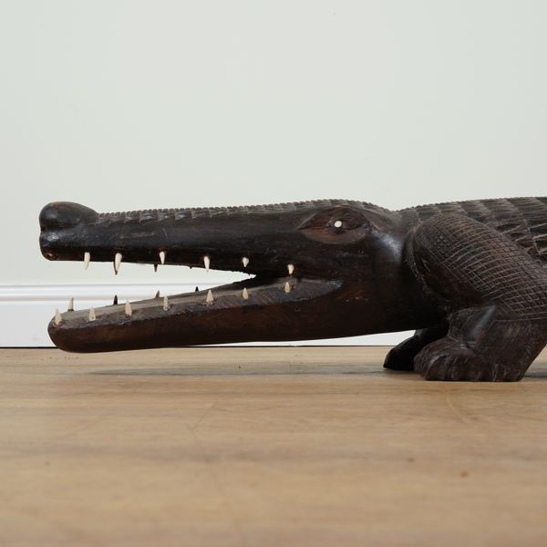 A LARGE TRIBAL STYLE CARVED HARDWOOD MODEL OF A CROCODILE